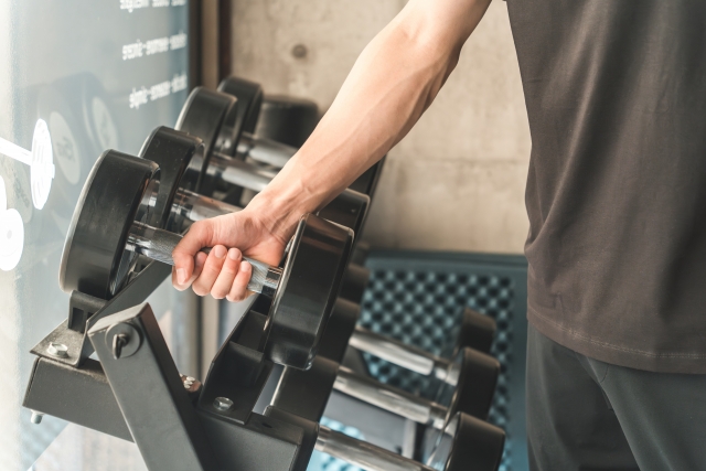 ダンベルを持ち上げようとする男性の右腕
